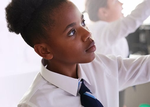 A schoolgirl writes on a whiteboard, to signify that the SCQF supports school pupils