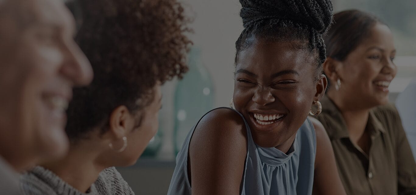 Four learners sitting side by side. Two the learners are looking at each other and smiling. The other two learners are looking ahead and smiling. They represent the learners that Recognition of Prior Learning (RPL) could benefit