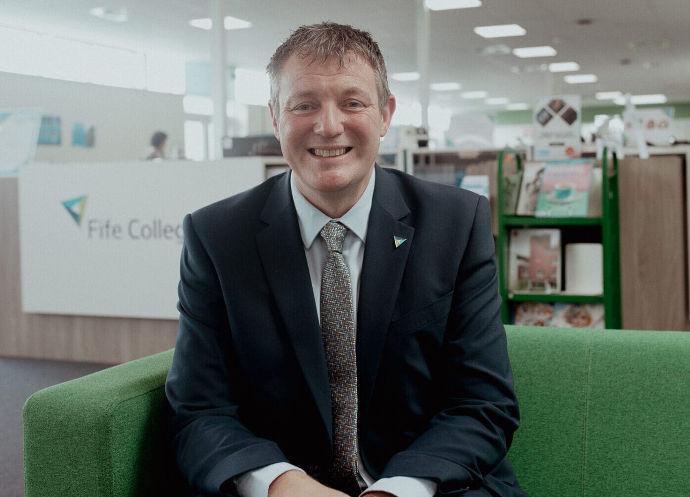 Iain Hawker sitting in the library at Fife College