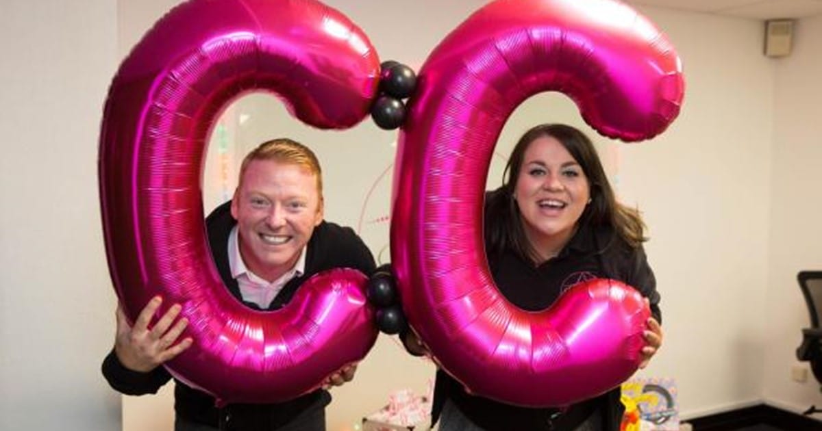 Anna Devitt, CEO of DirectDevitt with colleague holding 2 large pink C balloons