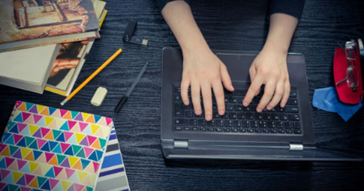 Fingers tapping on a laptop keyboard