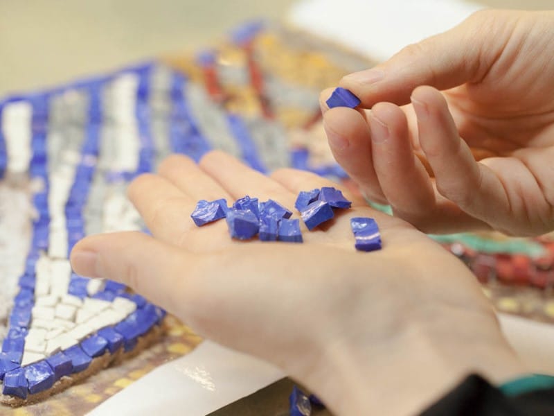 Bits of purple mosaic in student's hand
