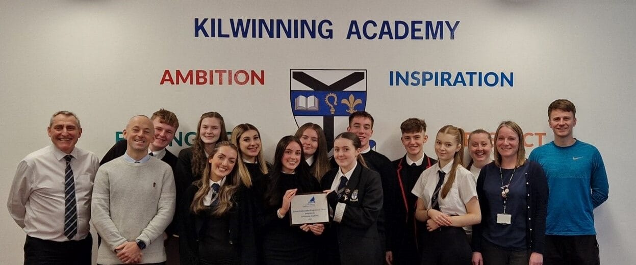 Kilwinning Academy pupils and staff hold up the Silver SCQF Ambassador plaque