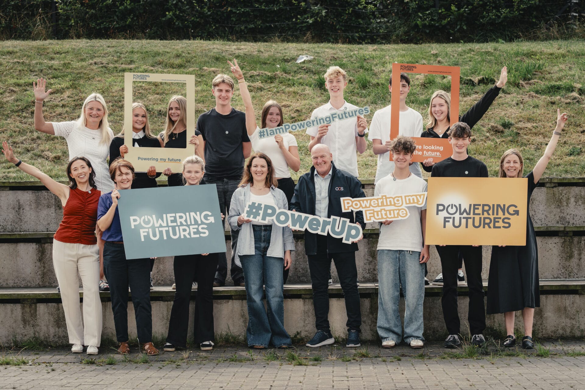 Powering Futures team holding up various banners and frames, smiling
